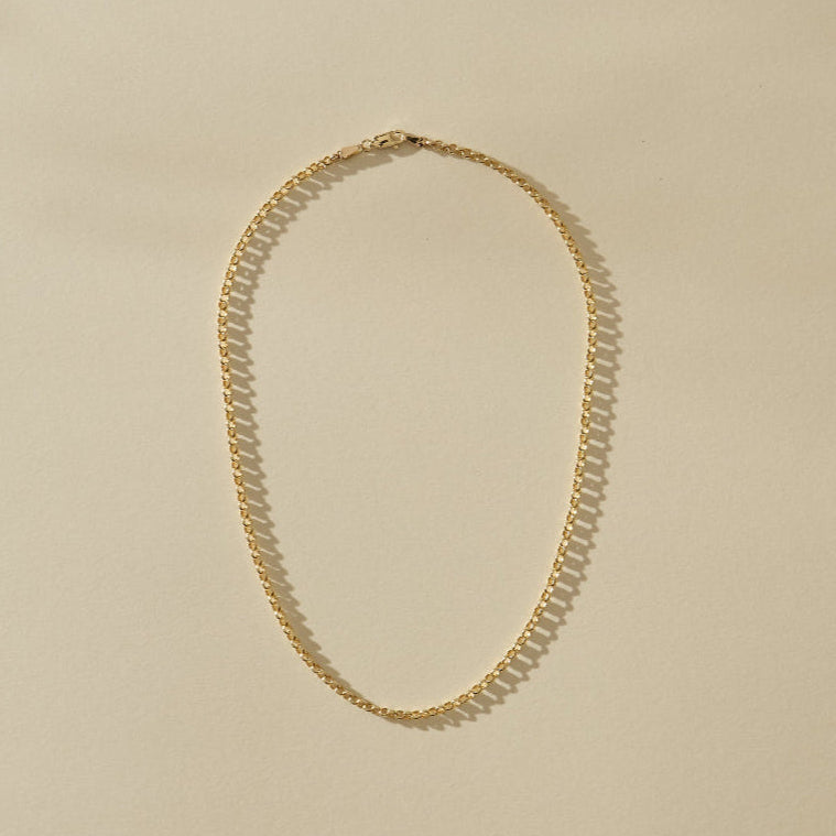 Gold necklace on a beige background