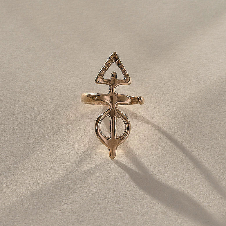 Gold ring with a unique design on a beige fabric background