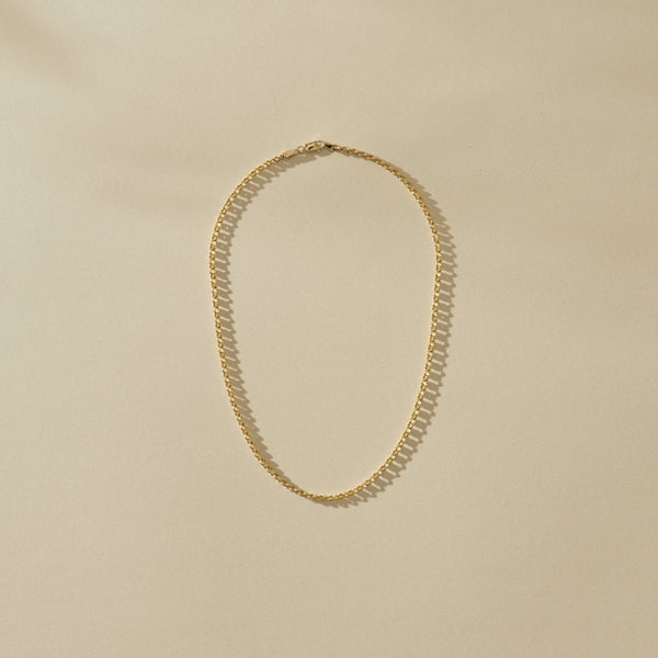 Gold necklace on a beige background