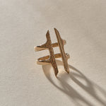 Akash Shield Statement Ring in recycled bronze at an angle, showing the carved shield bars and open design.