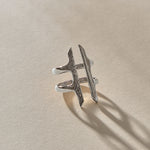 Akash Shield Statement Ring in recycled sterling silver at an angle, showing the carved shield bars and open design.