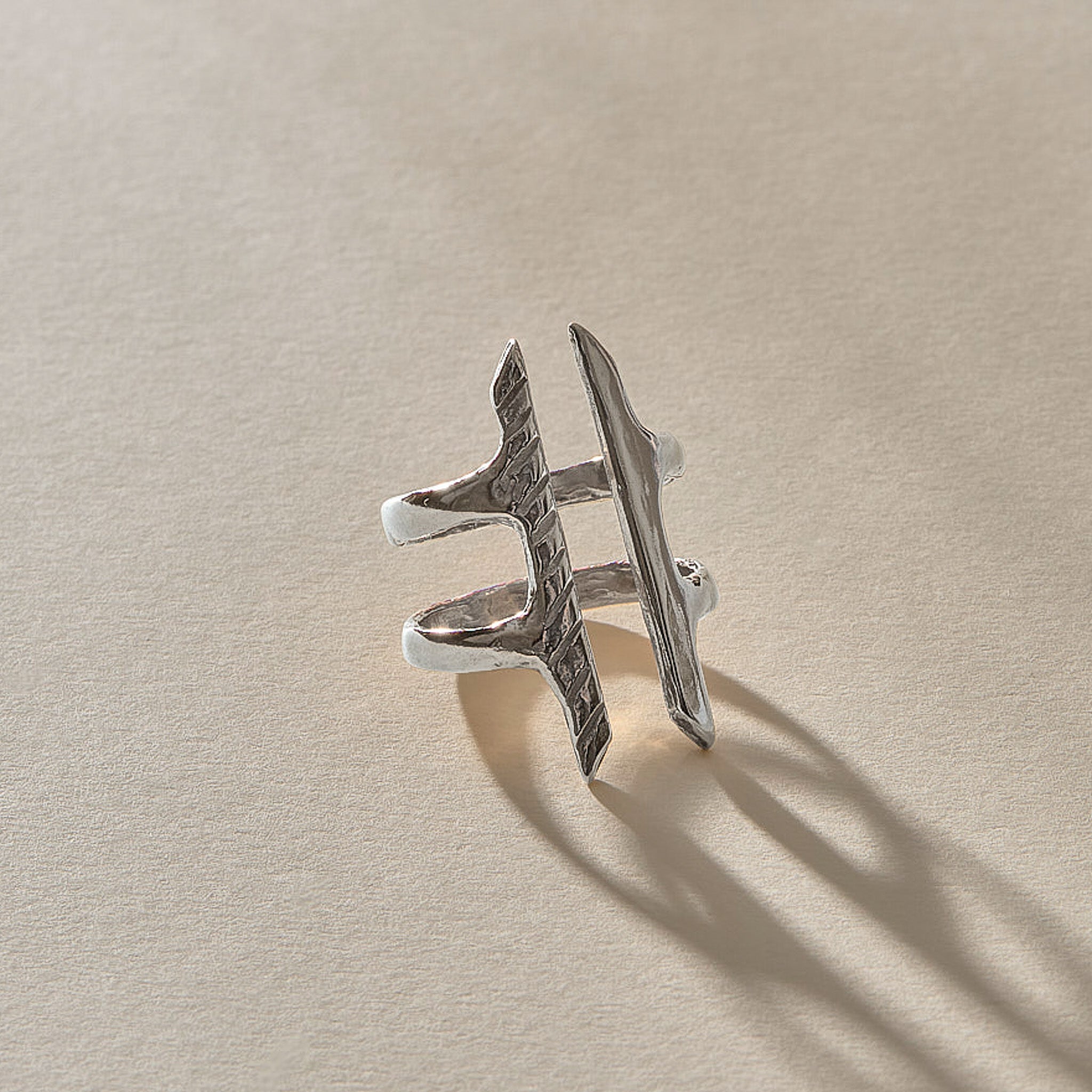 Akash Shield Statement Ring in recycled sterling silver at an angle, showing the carved shield bars and open design.
