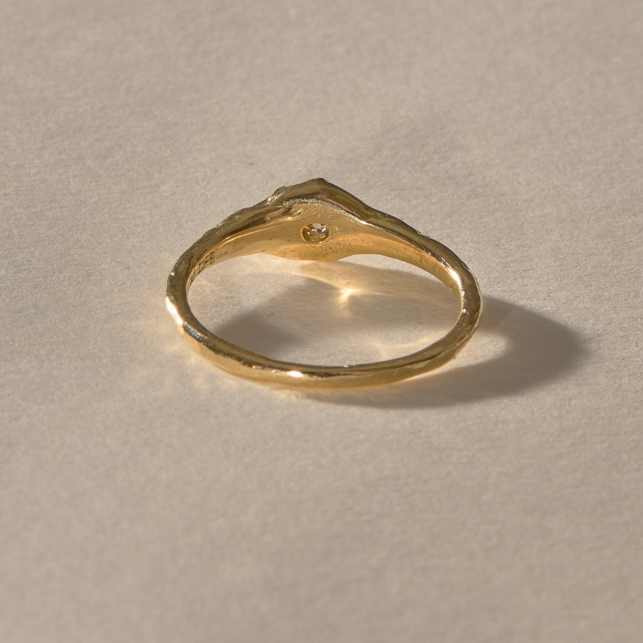 Ama Champagne Diamond Ring in gold from a rear angle, the diamond setting rising from the band.