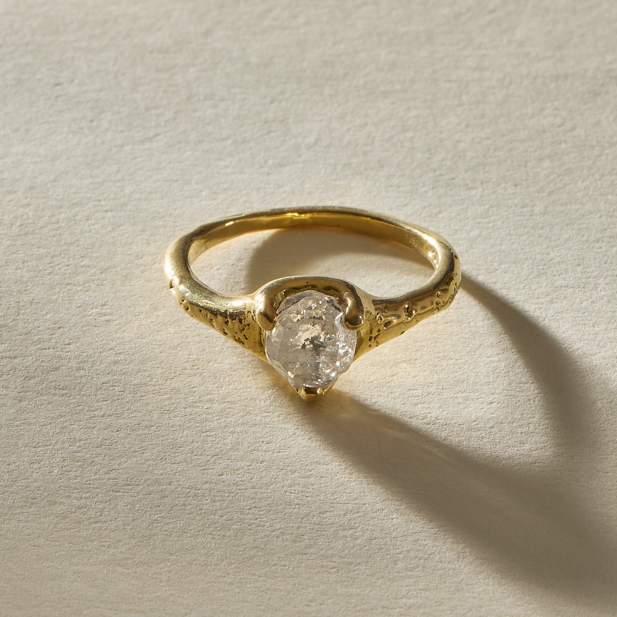 Amara polished raw diamond ring in 18k gold from the front, showing the natural, cloudy character of the stone.