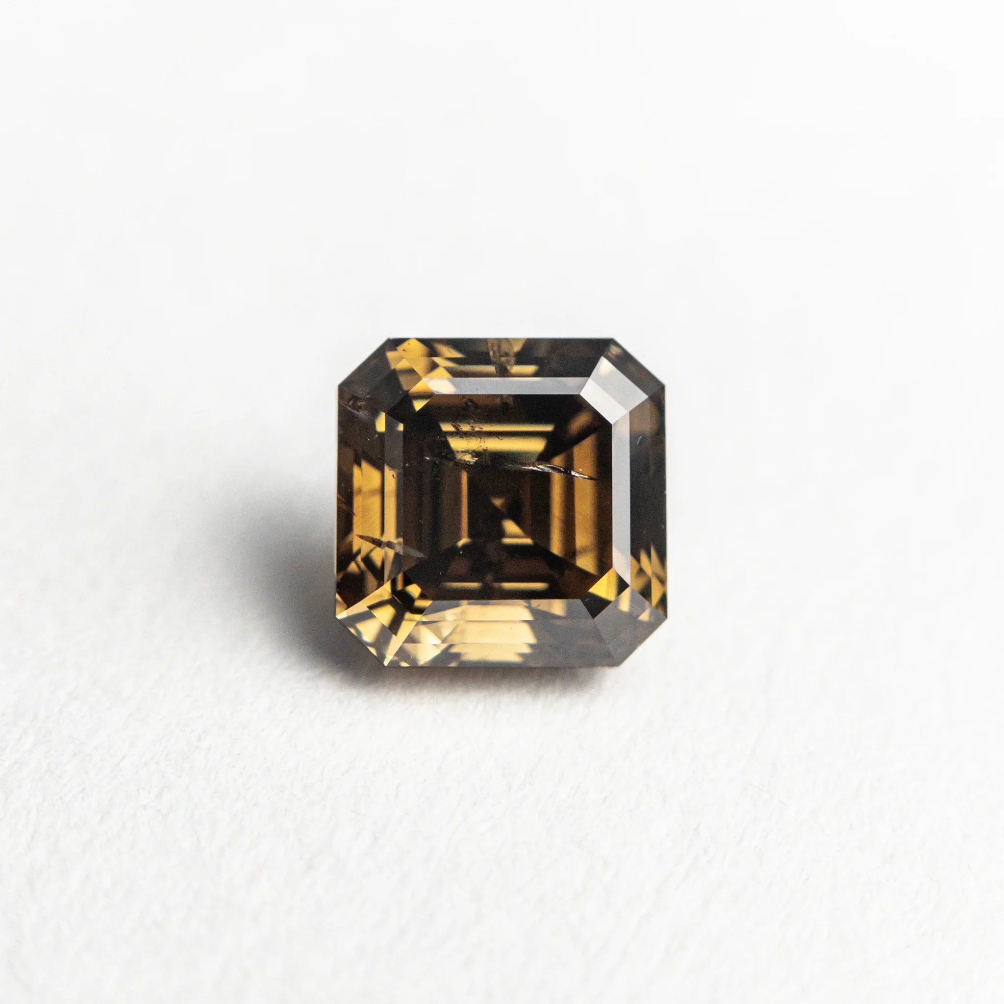 The 1.02ct square step cut champagne diamond set in the Ambre Ring, shown loose on a white background.