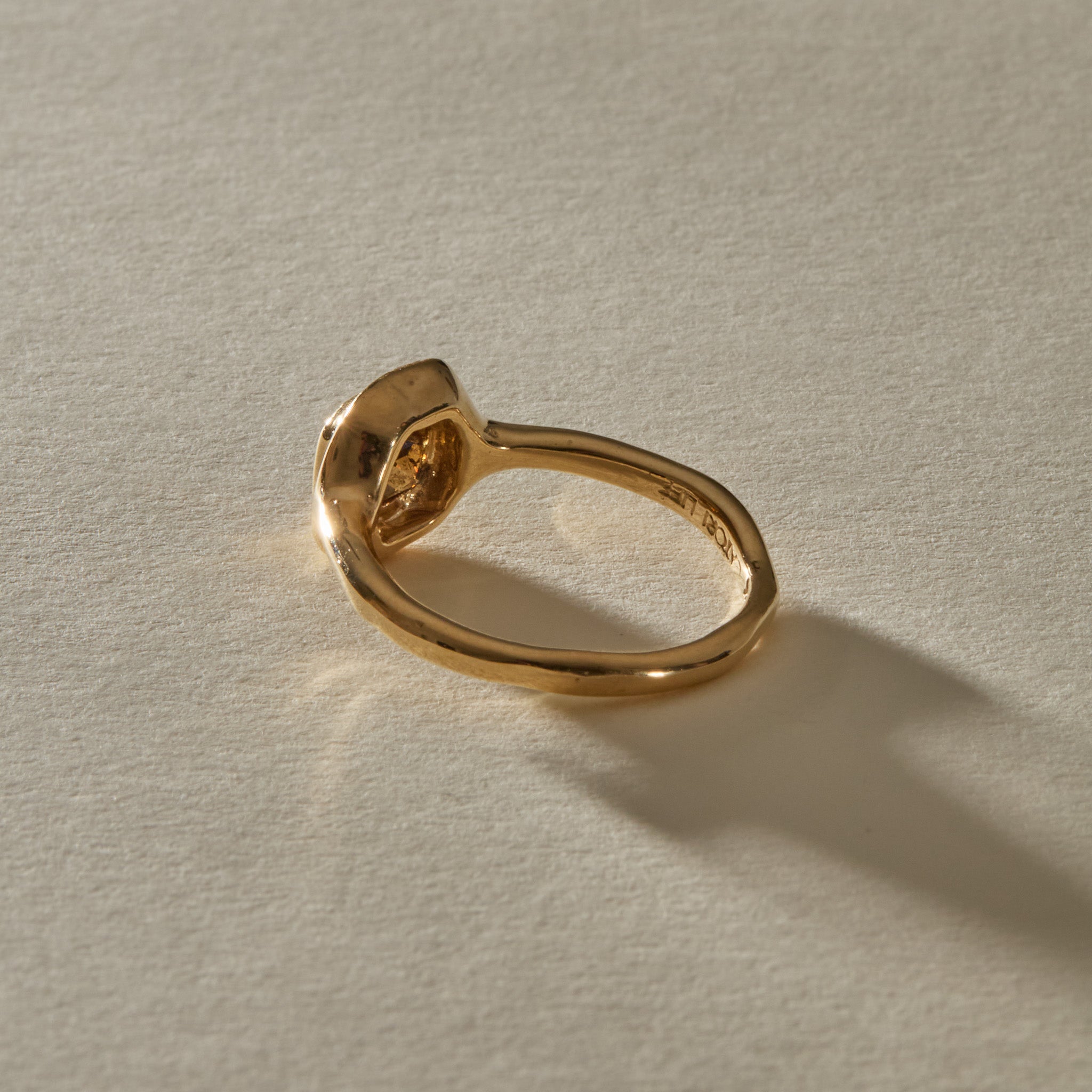 Ambre Ring in 14k recycled gold from behind, with the band curving up into the diamond setting.