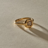 Ambre Ring in 14k recycled gold with a 1.02ct square step cut champagne diamond in a soft bezel, in warm sunlight.