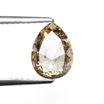 The 1.35ct champagne salt and pepper pear rose cut diamond held in tweezers before setting.