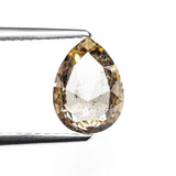 The 1.35ct champagne salt and pepper pear rose cut diamond held in tweezers before setting.