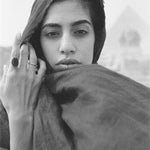 Model holding a scarf to her face, wearing a Black Tourmaline Amulet Ring in recycled gold.