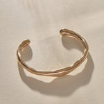 Bone Cuff Bracelet in bronze at an angle, showing the open ends and hand-carved texture.