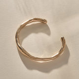 Bone Cuff Bracelet in bronze from the side, the band thickening and thinning along its curve.