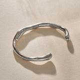 Bone Cuff Bracelet in sterling silver at an angle, showing the open ends and hand-carved texture.