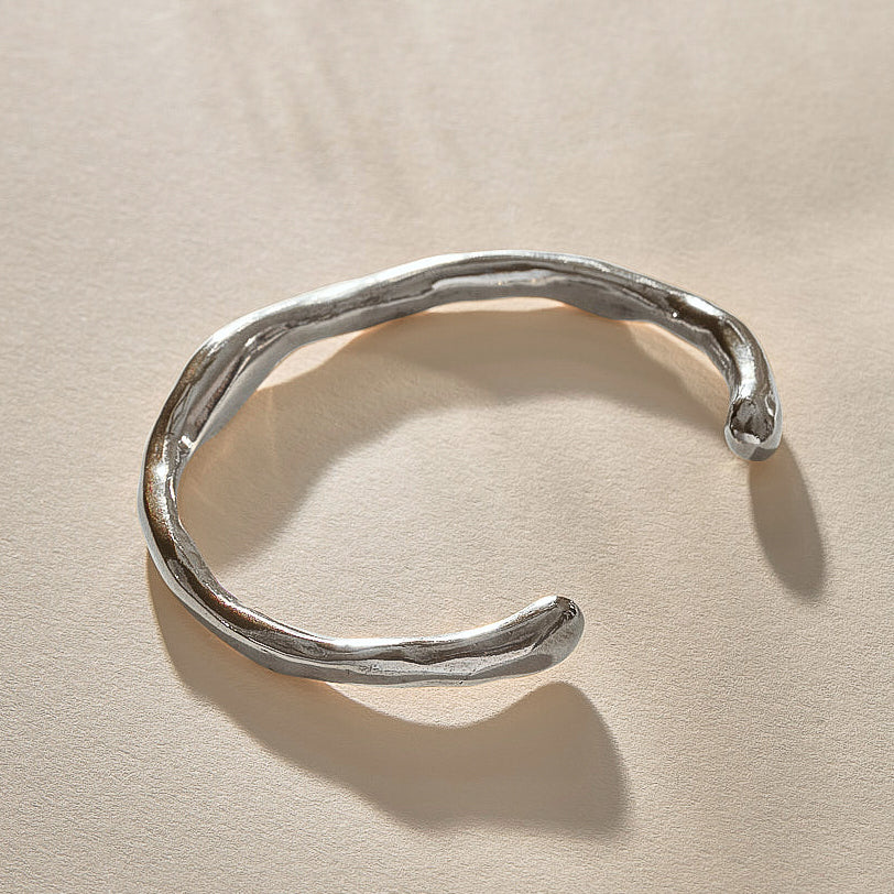 Bone Cuff Bracelet in sterling silver at an angle, showing the open ends and hand-carved texture.