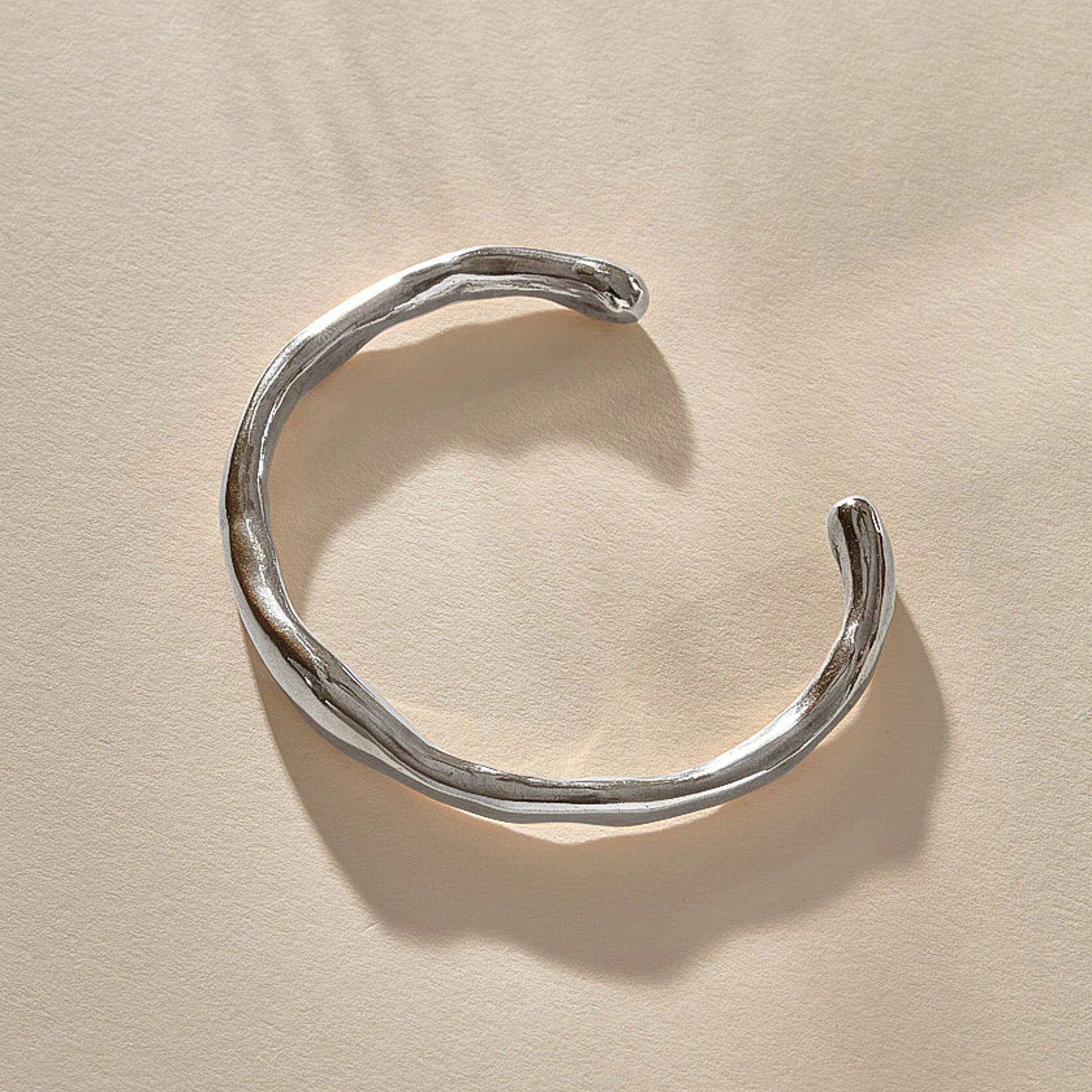 Bone Cuff Bracelet in sterling silver from the front, the band thickening and thinning along its curve.