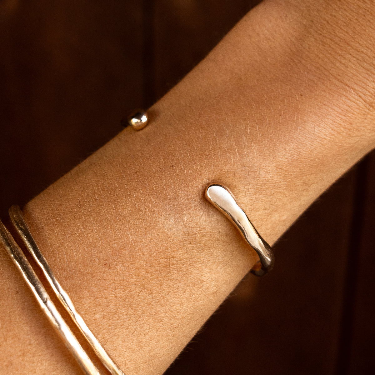 Bone Cuff Bracelet worn on the wrist against a dark background.