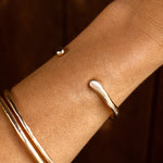 Bone Cuff Bracelet worn on the wrist against a dark background.