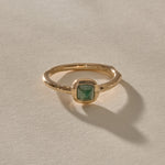 Cosmos Emerald Ring in solid recycled gold, a square sugarloaf emerald cabochon in a bezel on an organic band.
