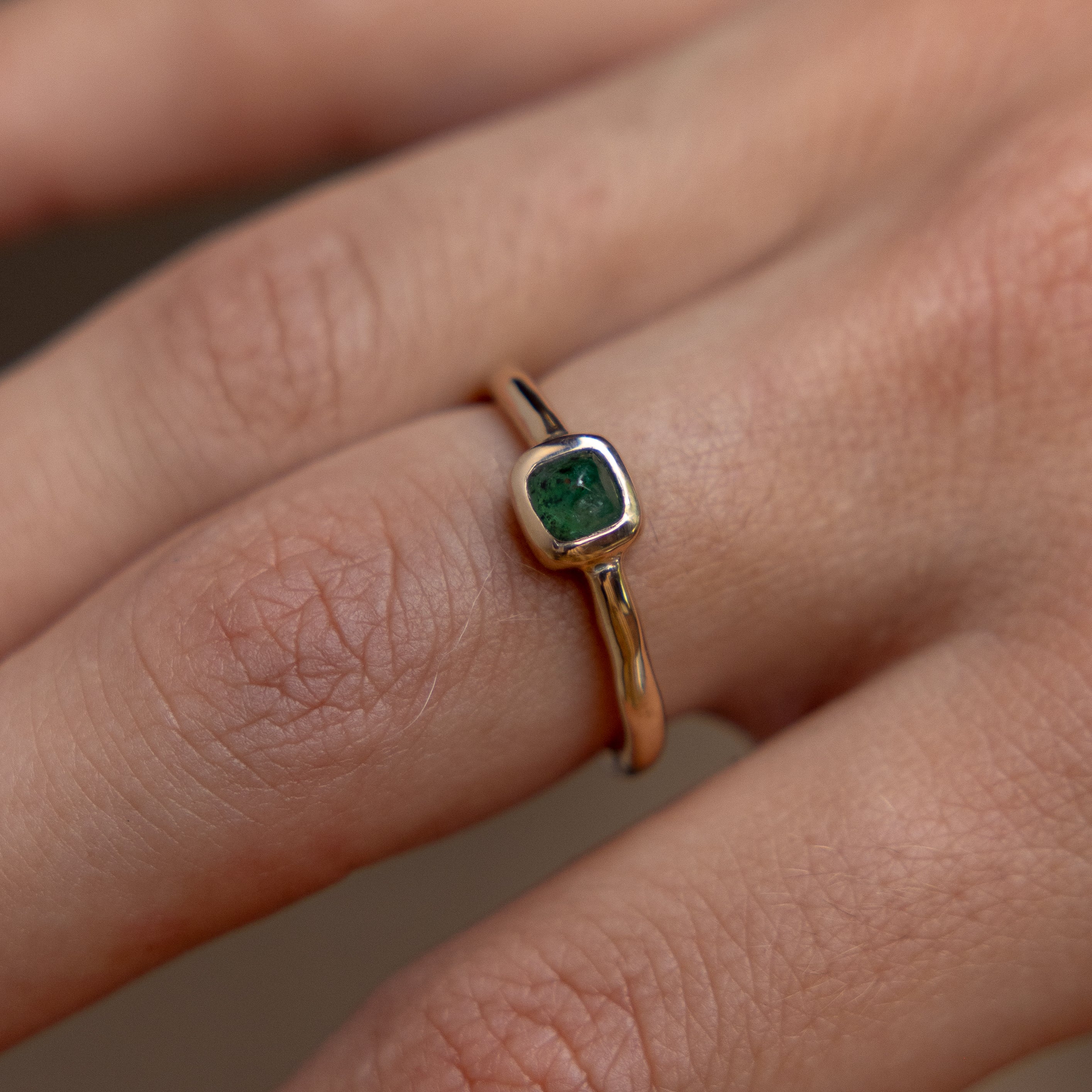 Cosmos Emerald Ring in solid recycled gold worn on the finger.