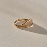 Devotions Wave Ring in recycled bronze at an angle, showing the carved wave face.
