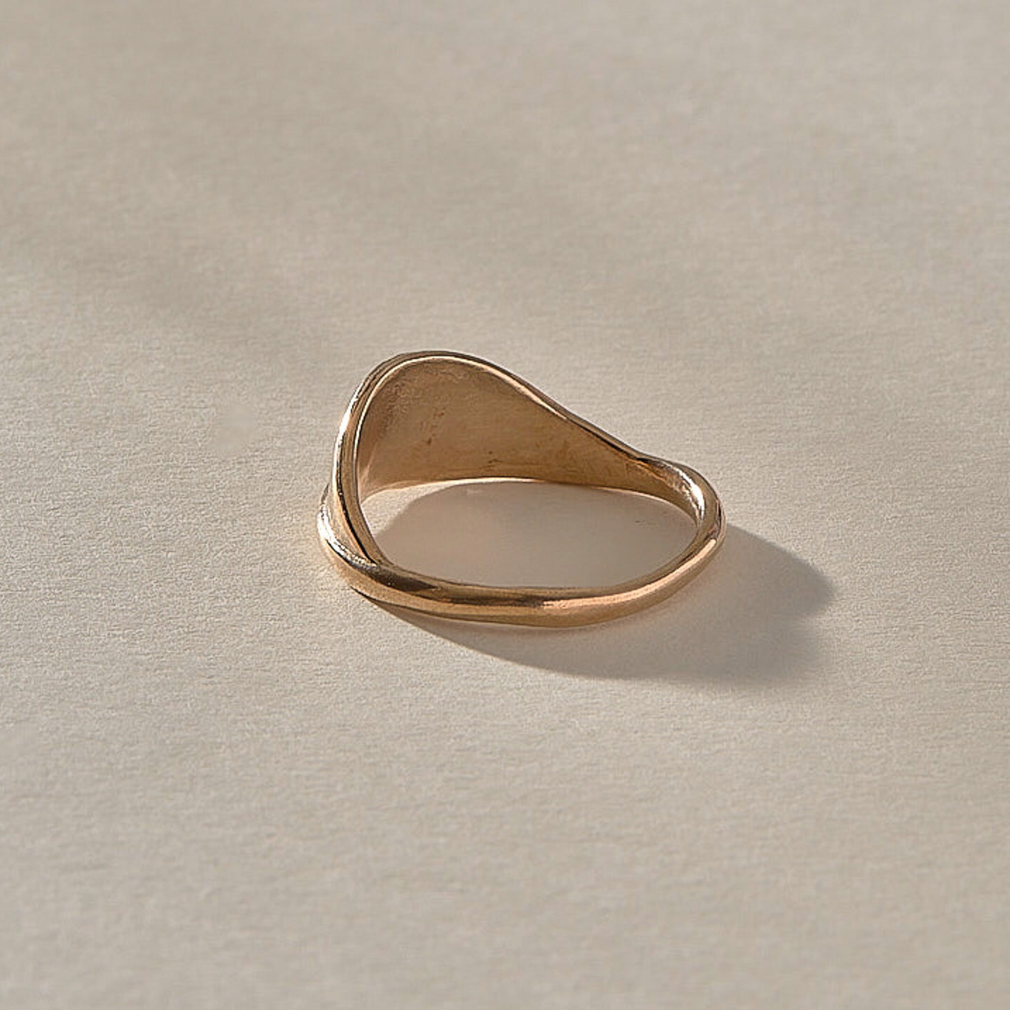 Devotions Wave Ring in recycled bronze from the front, showing the smooth rising band.