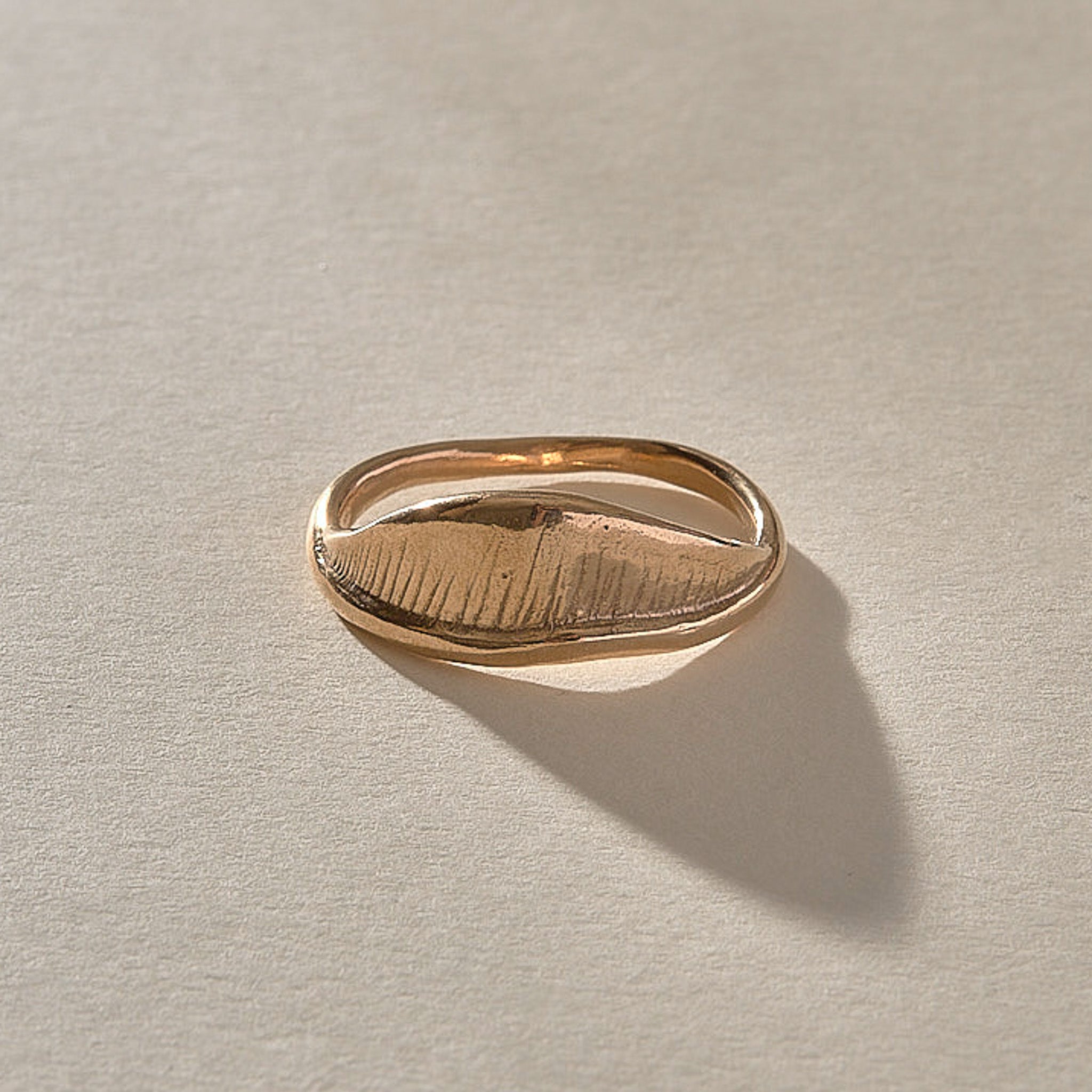 Devotions Wave Ring in recycled bronze, showing the fine carved lines across the wave.