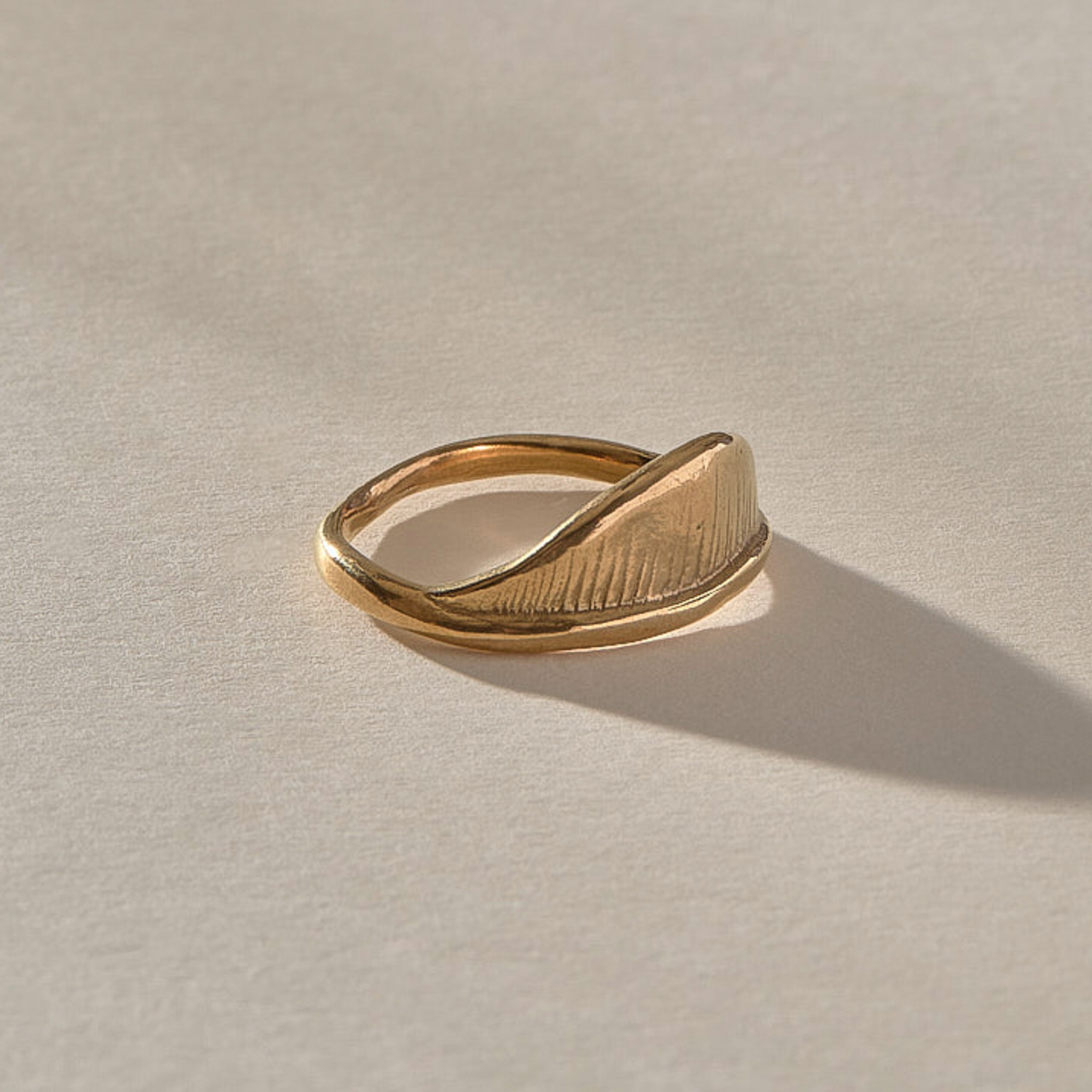 Devotions Wave Ring in solid recycled gold at an angle, showing the textured wave face.
