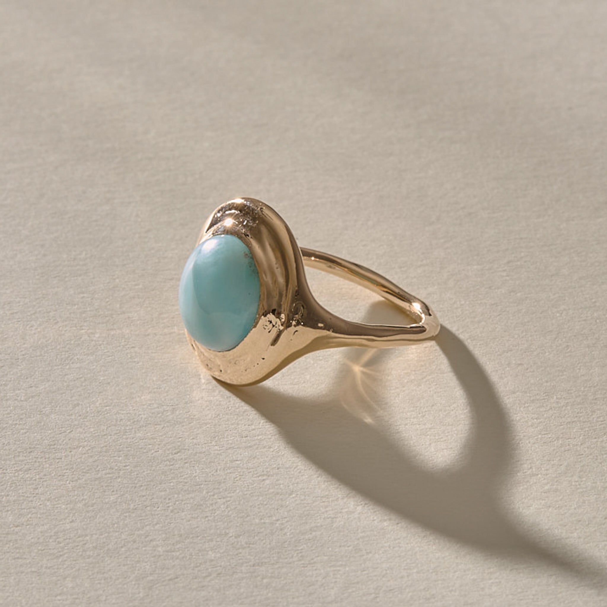 Elysian Larimar Signet Ring in solid recycled gold at an angle, showing the round larimar cabochon.