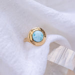 Elysian Larimar Signet Ring in solid recycled gold resting on soft white linen.