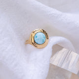 Elysian Larimar Signet Ring in solid recycled gold resting on soft white linen.