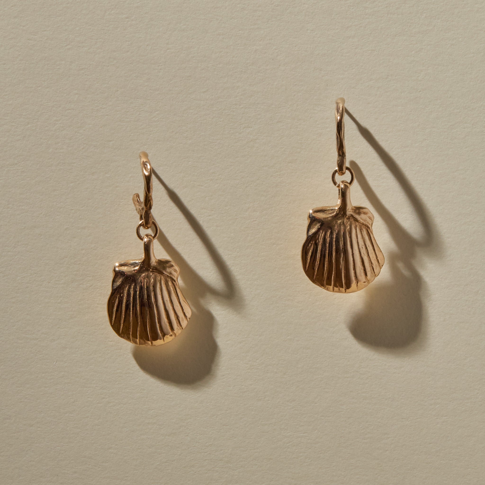 Elysian Shell Hoop Earrings in recycled bronze, cast scallop shells hanging from small hoops.