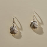 Elysian Shell Hoop Earrings in sterling silver, a pair of ribbed scallop shells catching the light.