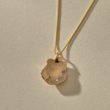 Back of the Elysian Shell Necklace pendant in bronze, showing the smooth inside of the shell.