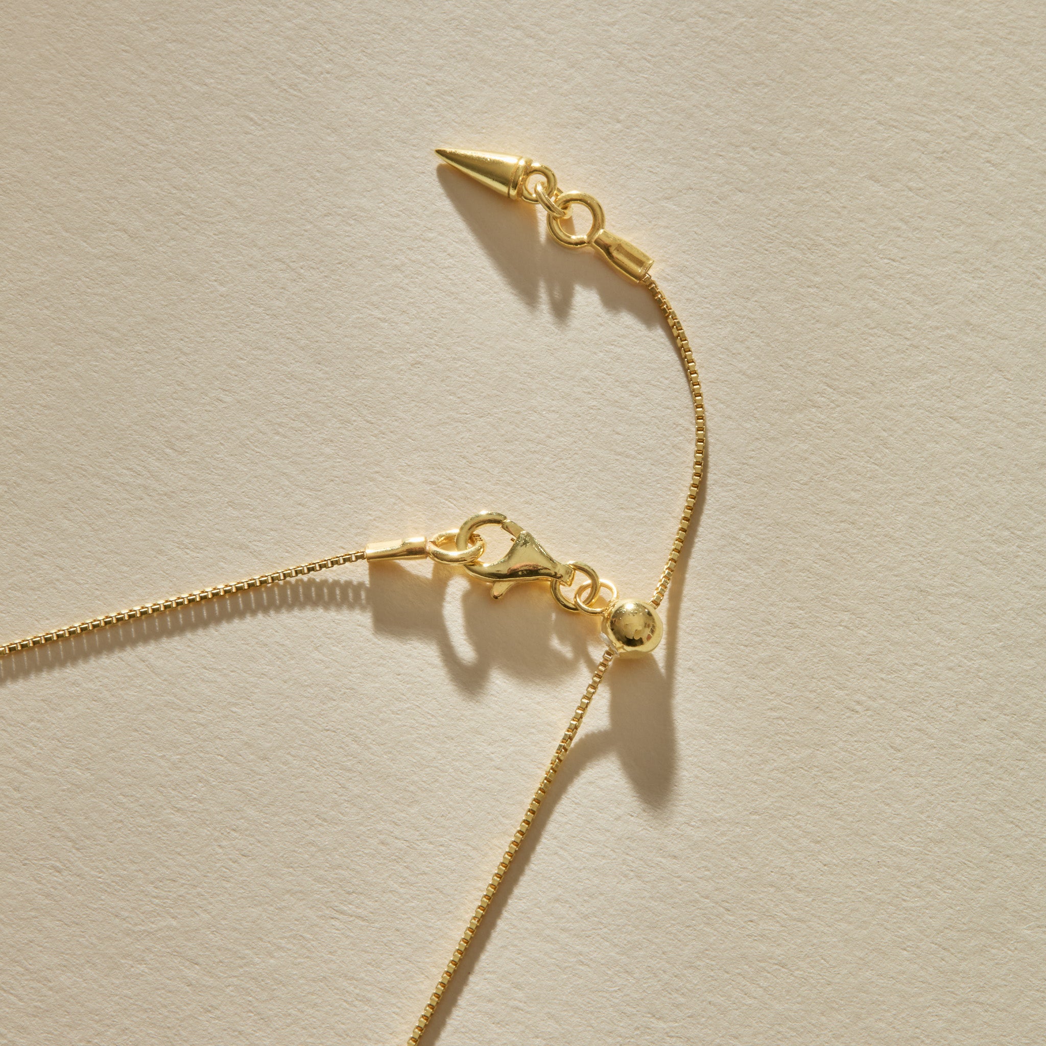 Clasp and adjustable chain of the Elysian Shell Necklace in gold.