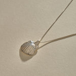 Elysian Shell Necklace in sterling silver, the ribbed scallop shell pendant at an angle.