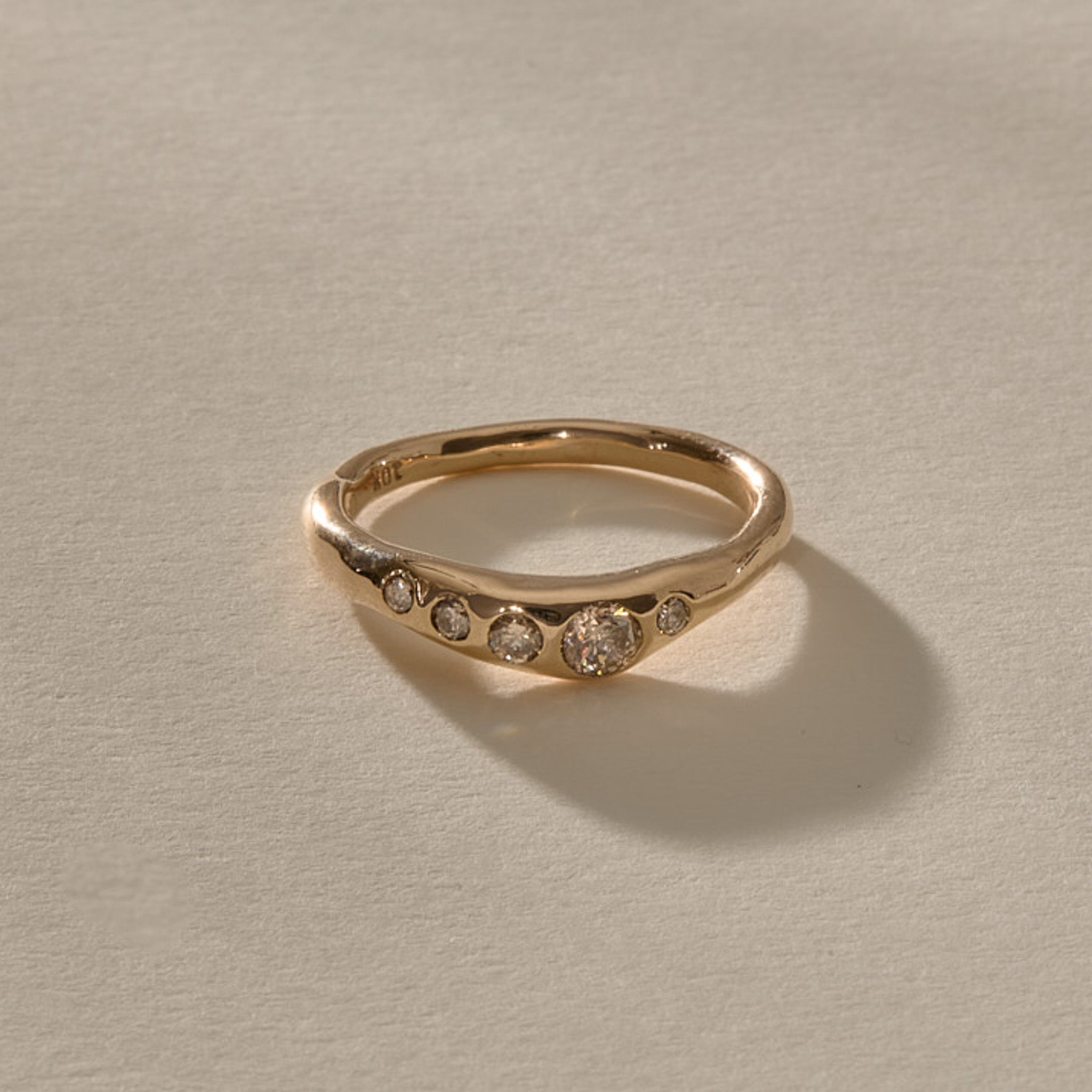 Eros Five-Stone Champagne Diamond Band in solid recycled gold at an angle, showing the graduated champagne diamonds.