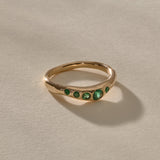 Eros Five-Stone Emerald Band in solid recycled gold, five faceted green emeralds set across an organic band.