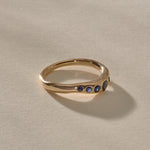 Eros Five-Stone Sapphire Band in solid recycled gold at an angle, showing the graduated blue sapphires.