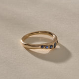 Eros Five-Stone Sapphire Band in solid recycled gold at an angle, showing the graduated blue sapphires.