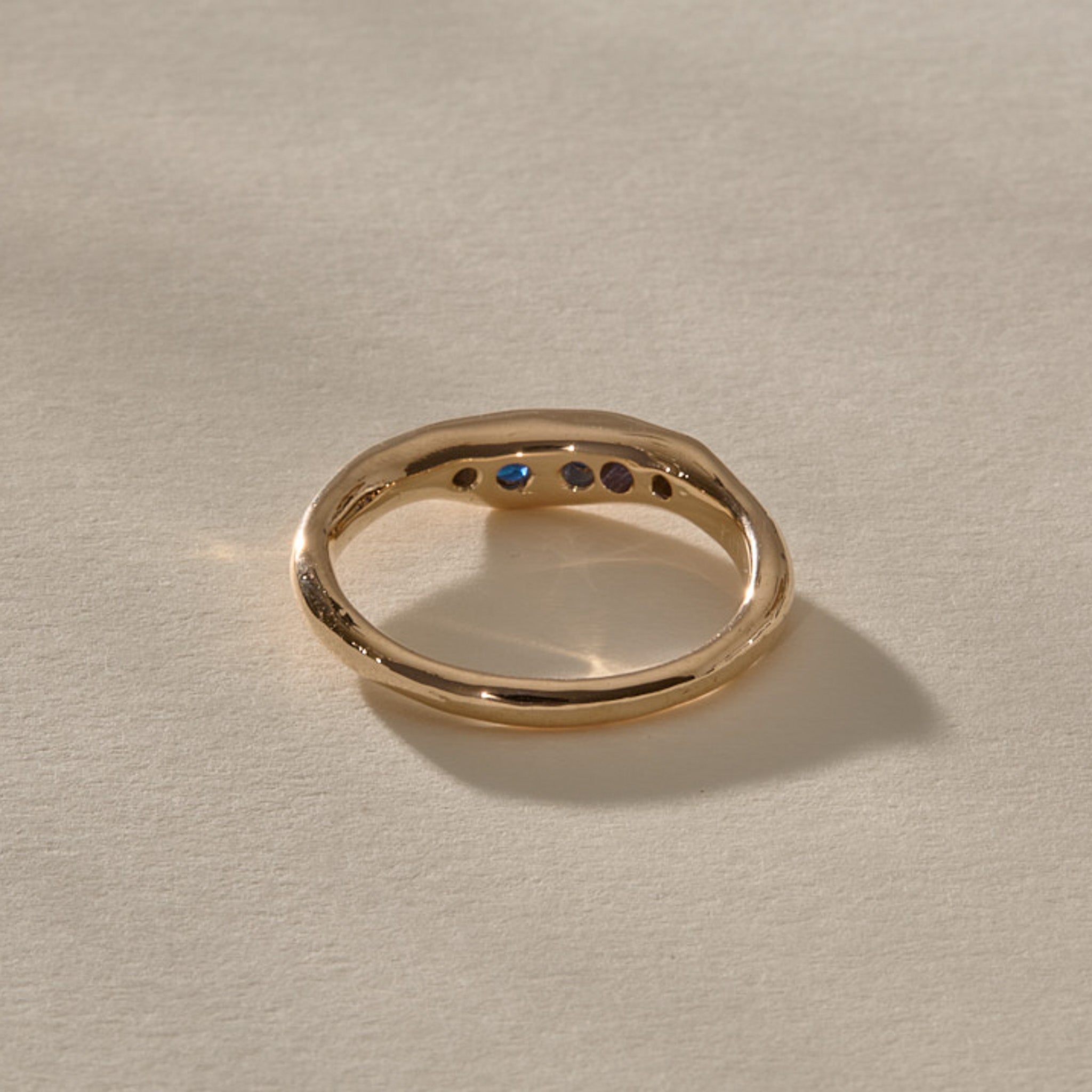 Eros Five-Stone Sapphire Band in solid recycled gold from the back, showing the sapphires through the open settings.