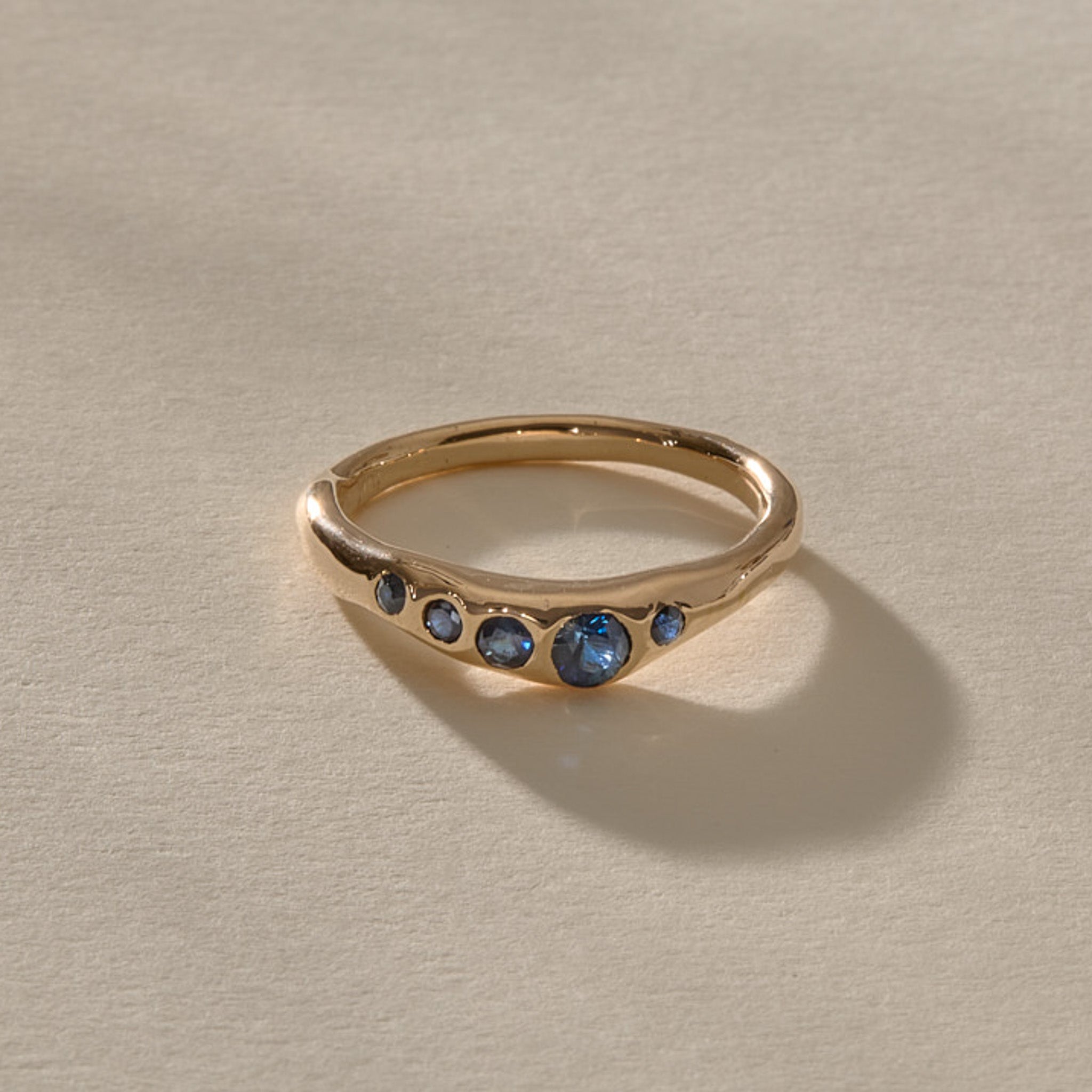 Eros Five-Stone Sapphire Band in solid recycled gold, five deep blue sapphires set across an organic band.