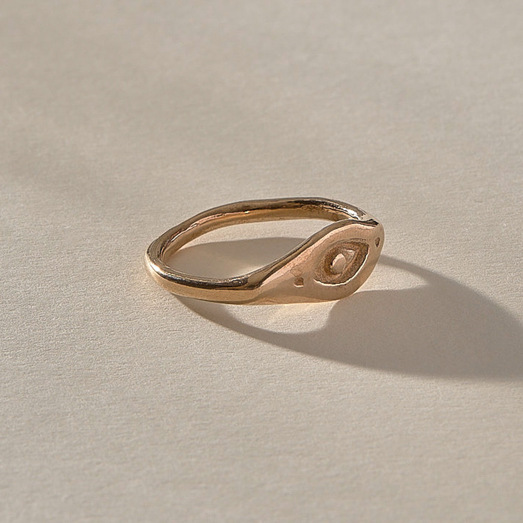Evil Eye Protection Ring in recycled bronze at an angle, showing the carved protective eye.