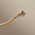Close up of the gold Fehu Herringbone Chain Bracelet lobster clasp.