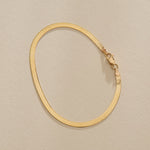 Fehu Herringbone Chain Bracelet in gold from above, fastened in an oval.
