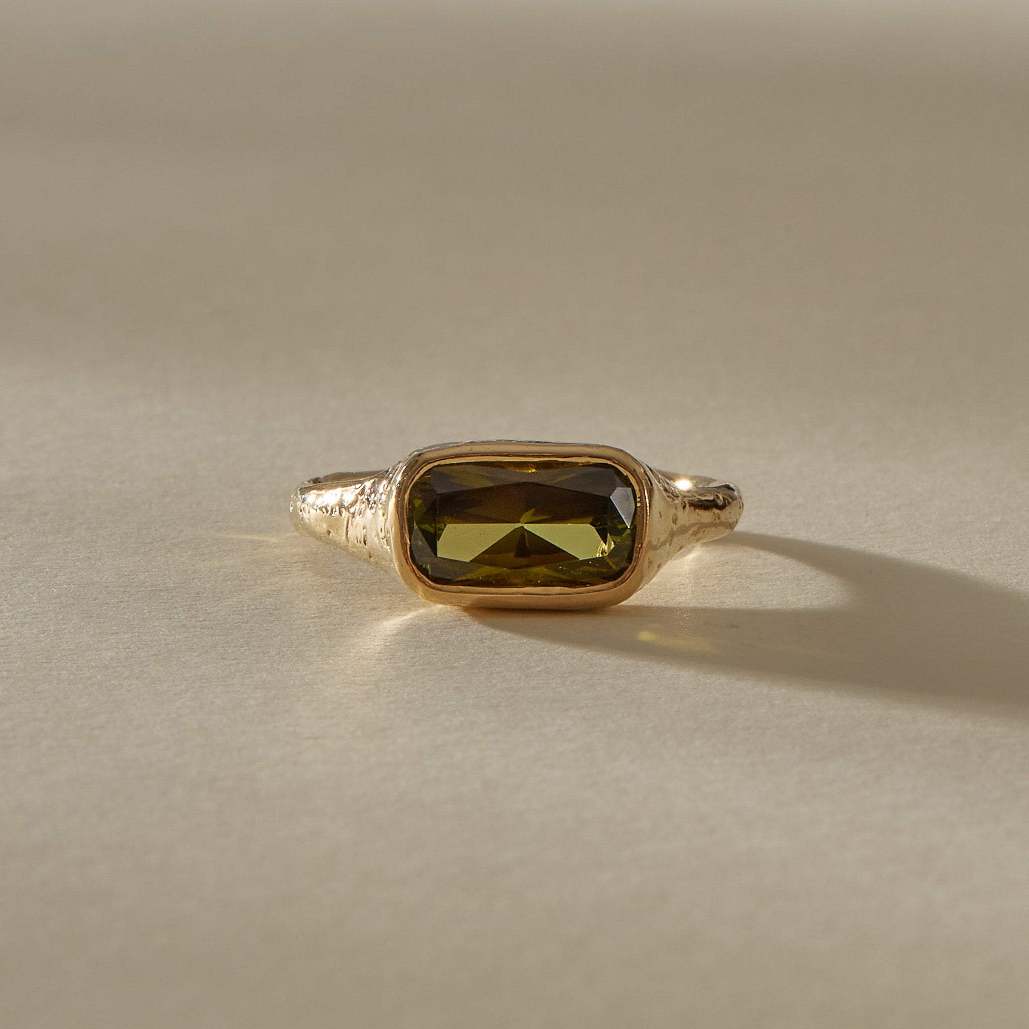 Green Tourmaline Signet Ring II in solid recycled 14k gold from the front at a low angle, showing the faceted green tourmaline.