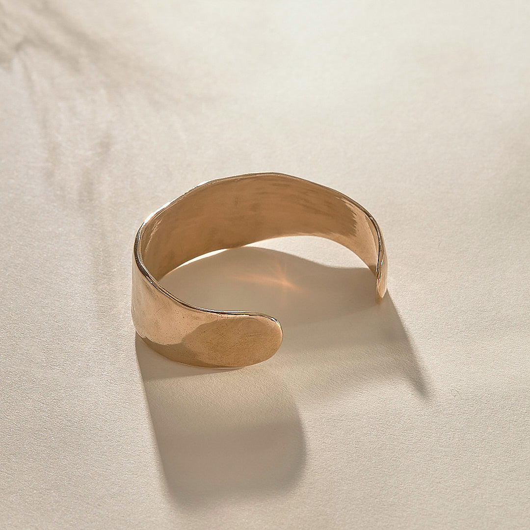 Guardian Hammered Cuff in bronze from the side, showing its wide, flowing band.