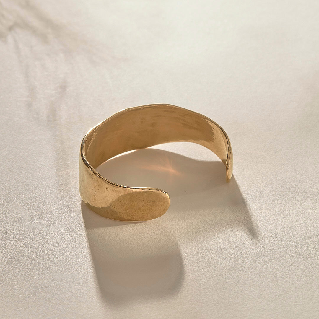 Guardian Hammered Cuff in gold from the side, showing its wide, flowing band.