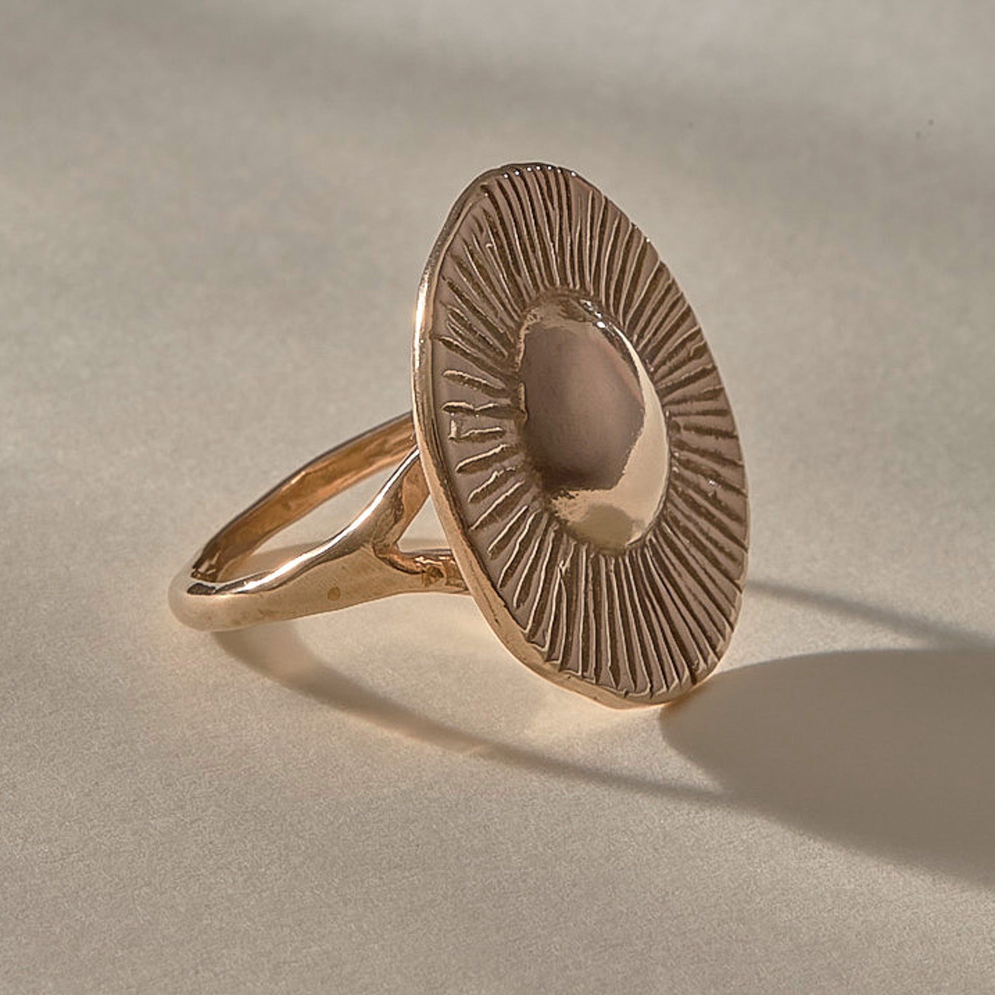 Heart of the Sun Statement Ring in recycled bronze from the side, showing the sunburst face and slim band.