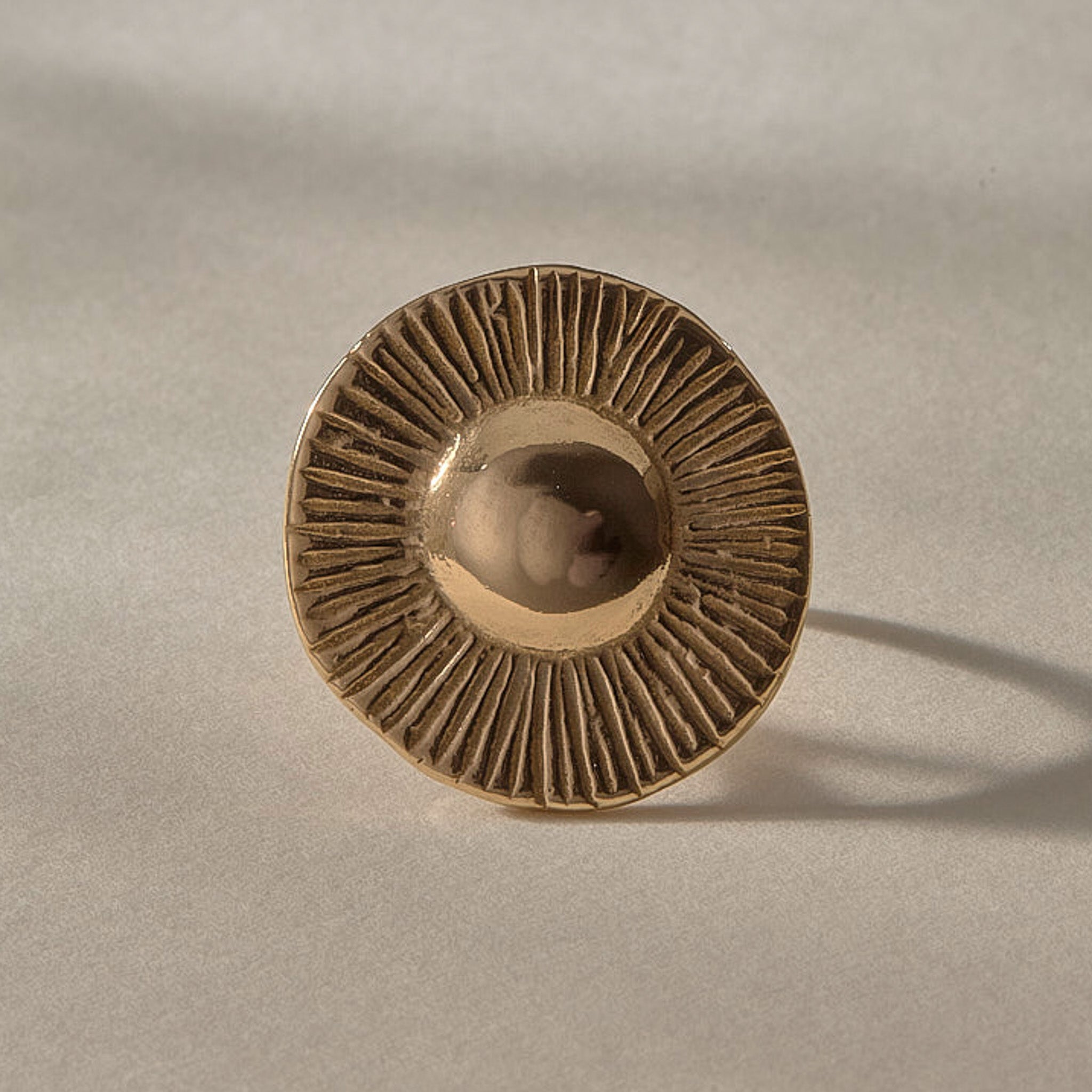 Heart of the Sun Statement Ring in solid recycled gold from the front, a domed center radiating fine carved rays.