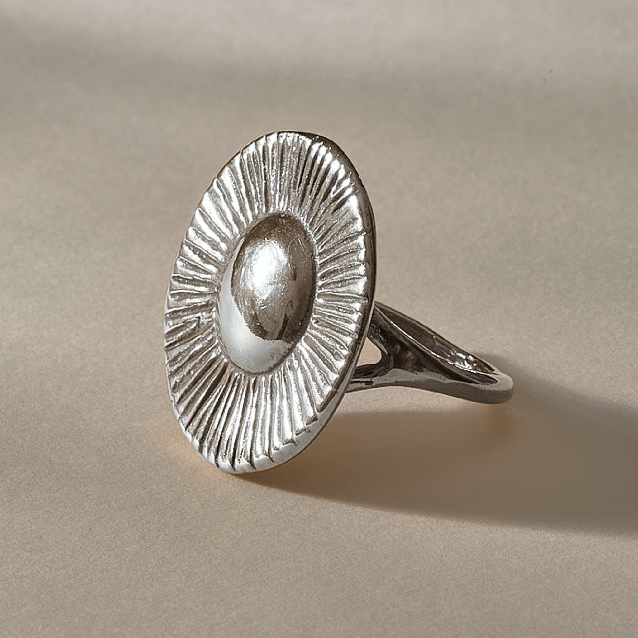 Heart of the Sun Statement Ring in recycled sterling silver at an angle, a domed center radiating fine carved rays.